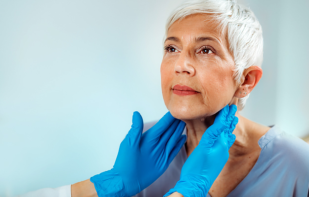 A mature woman having her thyroid gland examined by a doctor.