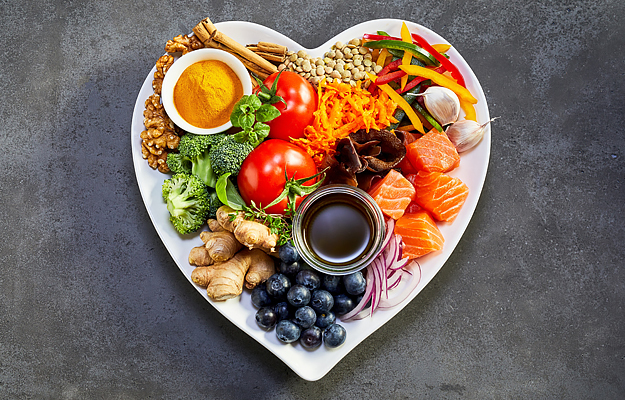 An assortment of healthy food on a heart-shaped plate.