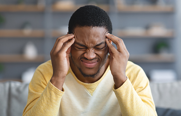 A man holding his head in pain.