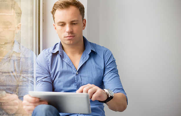 A man looking at a digital tablet.