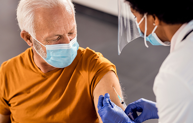A senior man getting vaccinated at a medical clinic.