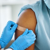 Doctor giving patient bandage on arm.