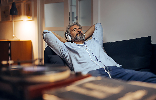 A mature man relaxing with headphones on.