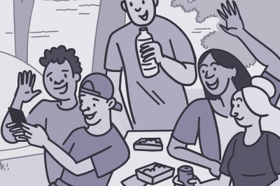 Group of friends taking a selfie outside at a picnic table