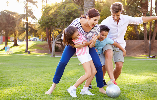 A family playing soccer outdoors.