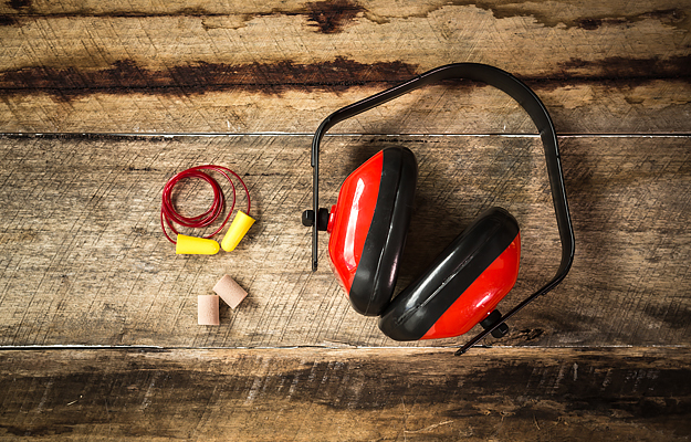 An assortment of ear protection on a wooden surface.