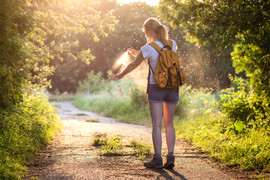 Woman applying insect repellent as mosquitoes fly around her