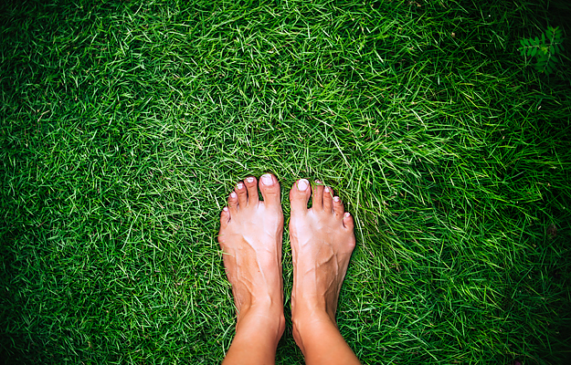Bare feet on top of grass.