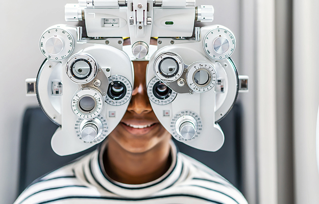 A woman getting an eye exam with a phoropter.