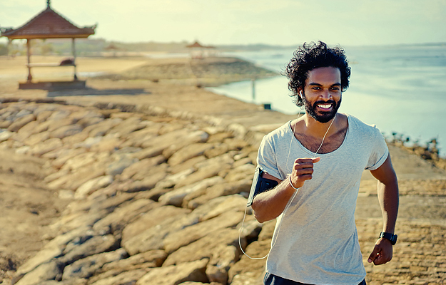 A man jogging by the shore.