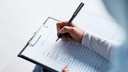 Woman writing on a notepad. 