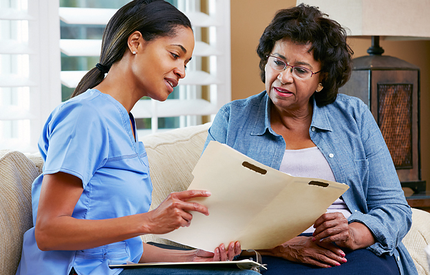 A nurse reviewing information with a mature female patient.