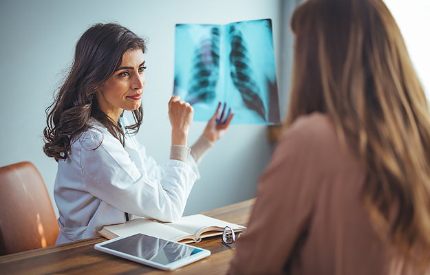 A doctor reviewing a chest X-ray with a patient.