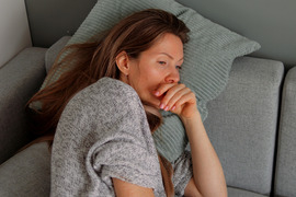 Tired woman lying on sofa.