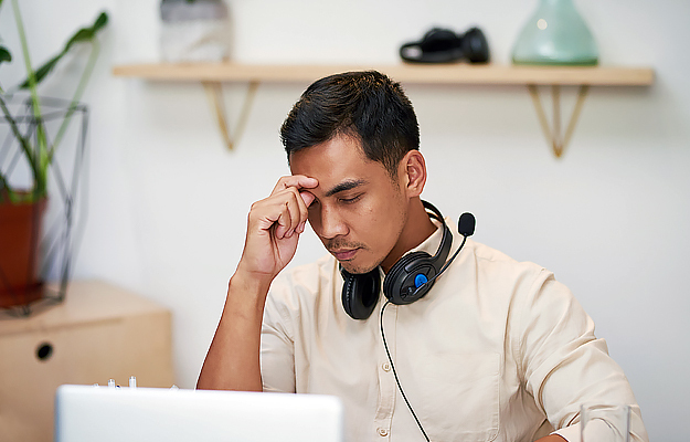 A man having difficulty concentrating at work.