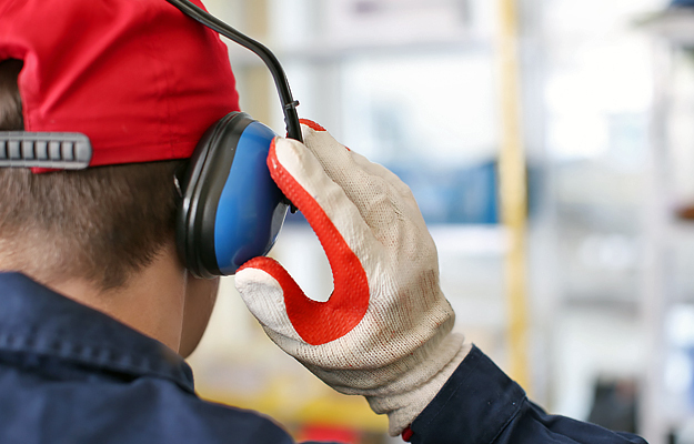 A close-up of a man wearing protective earmuffs.