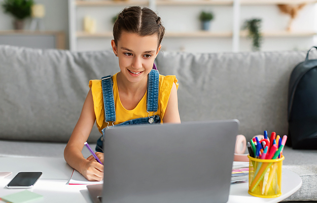 A young girl using a laptop.