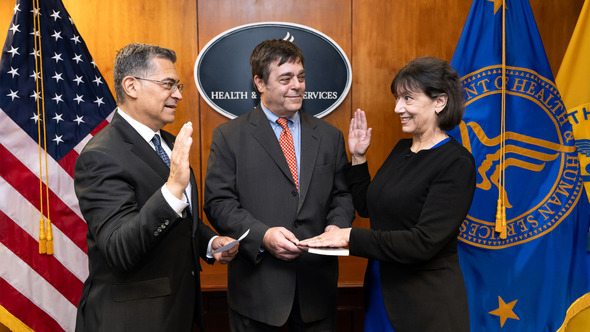 HHS Secretary Xavier Becerra (left) swears in Monica Bertagnolli (right) as NIH Director. Alex Dannenberg (center).