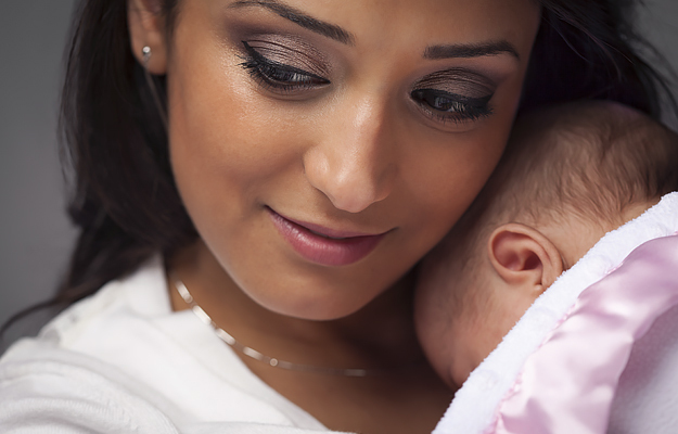 A close-up of a woman holding a newborn baby.