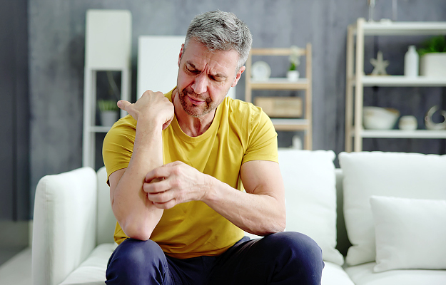 A man scratching his forearm.