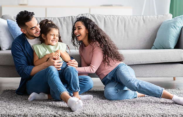 Parents having fun with their young daughter at home.