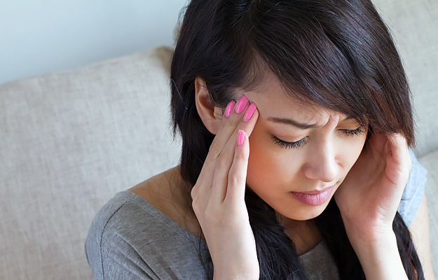 A woman holding her head in pain.