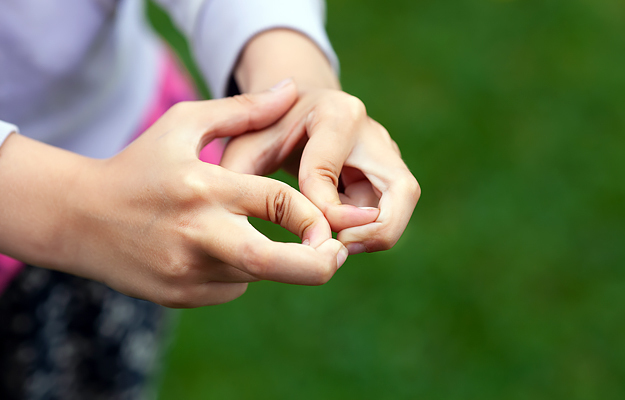 A close-up of a child's hands with hypermobile fingers.