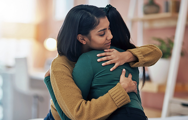 A woman comforting someone with a hug.