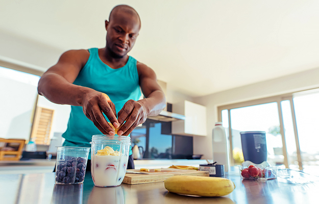 A man making a smoothie in a kitchen.