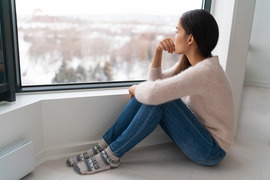 Young woman looking out the window in winter.