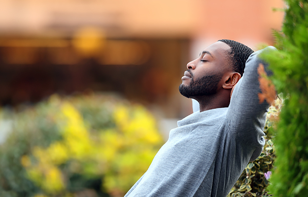 A man relaxing outside with his eyes closed.