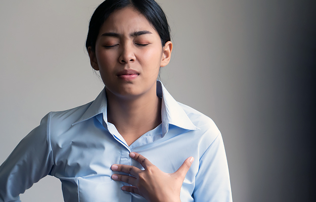 A woman holding her chest in pain.