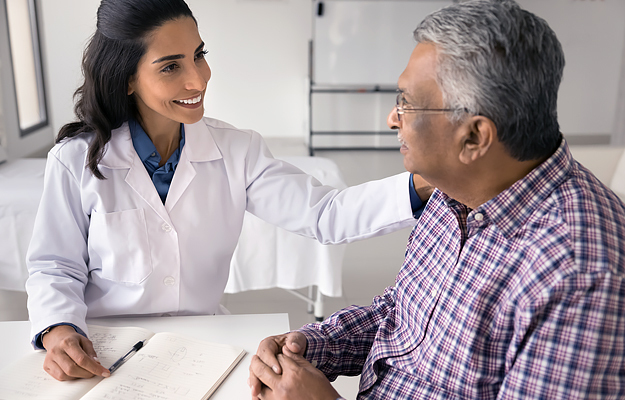 A female doctor comforting a senior male patient.