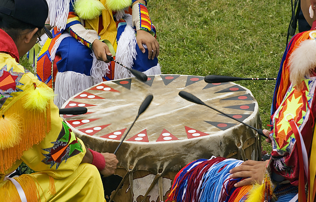 A Native American community playing drums at a powwow.