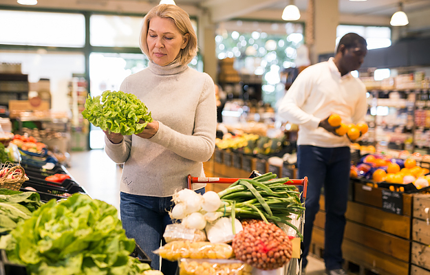 A middle-aged woman shopping for fresh vegetables.