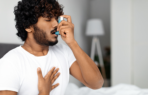 A man using an asthma inhaler.