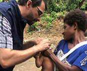 Dr. Hagan works with a mother holding her infant