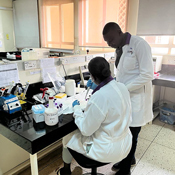 r. Alex Kayongo (standing) consults with a colleague