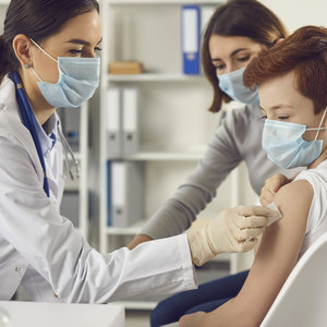 Health care provider administering vaccine to child with parent 