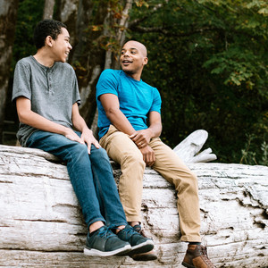 A man talks to his son on a beach in Washington state, enjoying the beauty of the Pacific Northwest.