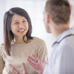 A woman is at the doctor's office and is getting good news after her check up.