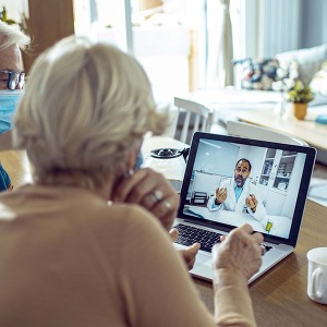 Woman on laptop talking to doctor 