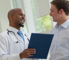 An medical assistant consulting with a patient who is participating in a clinical trial.