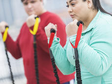 Latina women exercise with resistance bands