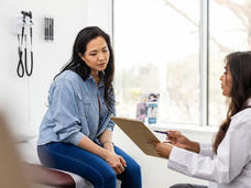 female patient in an exam room talking with doctor