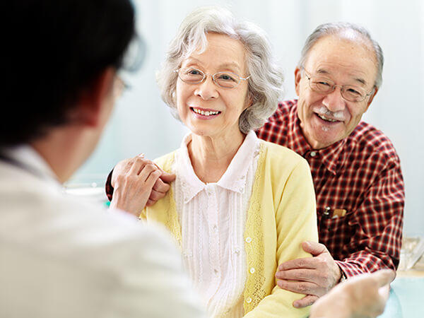 an older couple, one male, one female, talk with a doctor