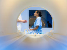 a view from a scanner of a woman in a hospital gown sitting on a table