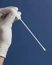 A gloved hand holds a long q-tip swab. 