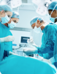 A surgeons in an operating room wearing scrubs, masks, and gloves.