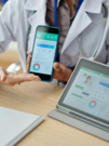 A medical professional holding a cellphone, displaying digital information.